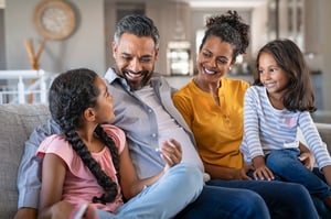 family hugging on couch 