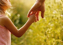 Child holding adult's hand