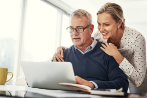 couple smiling while reviewing their trust documents
