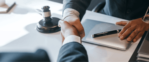 attorney shaking hands in meeting with client