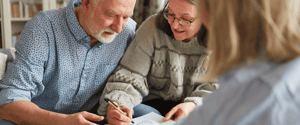 older couple signing documents