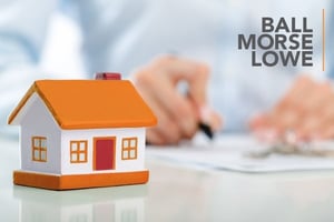 house model with someone signing a contract in the background