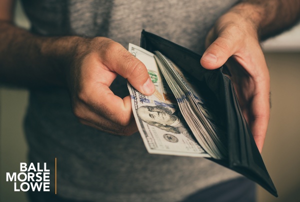 hands pulling money out of a wallet