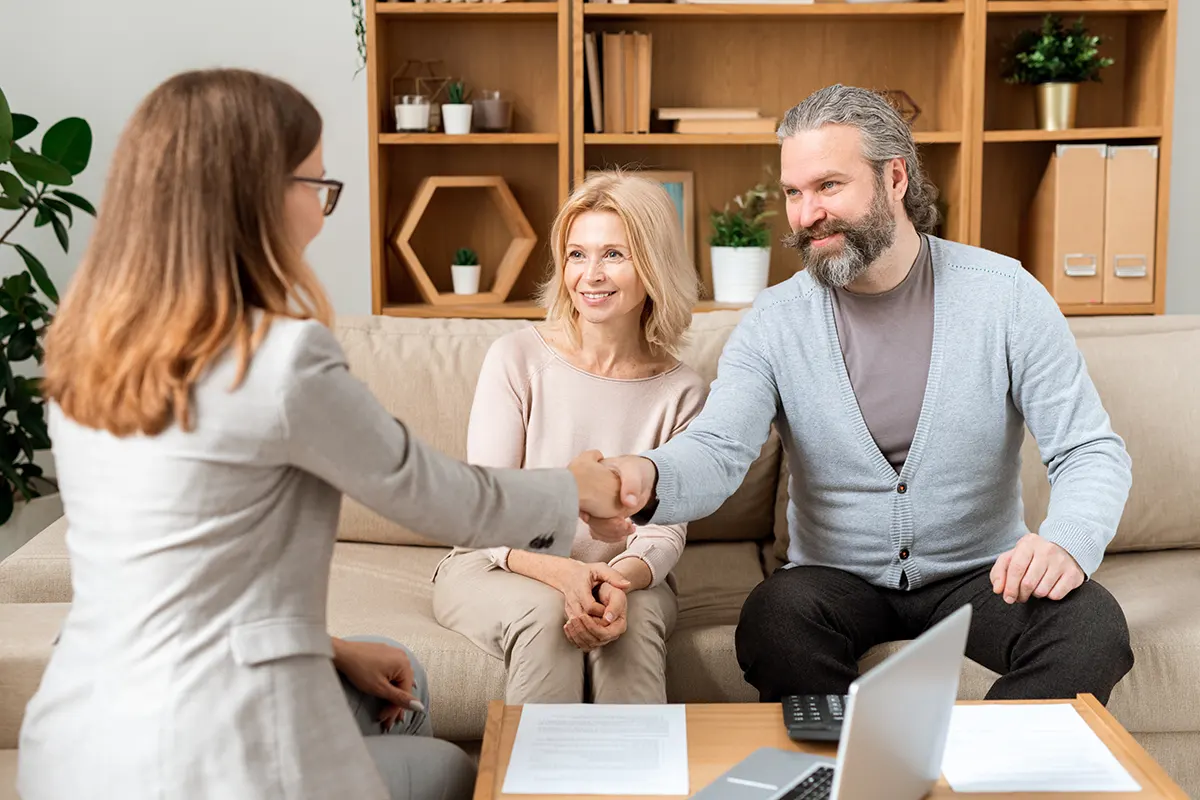 mature couple shaking hands with a lawyer